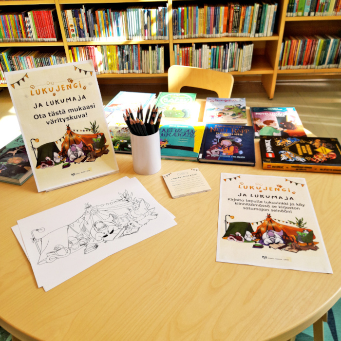 Kirjaston lastenosaston pöydällä on tarjolla vinkkilappuja sekä värityskuvia.